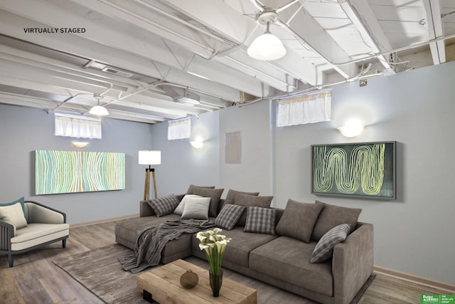 living area with wood finished floors, a wealth of natural light, and baseboards