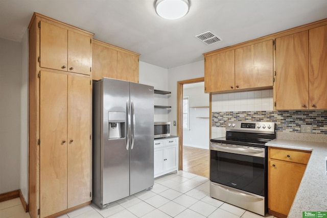 kitchen featuring light tile patterned flooring, visible vents, light countertops, appliances with stainless steel finishes, and backsplash