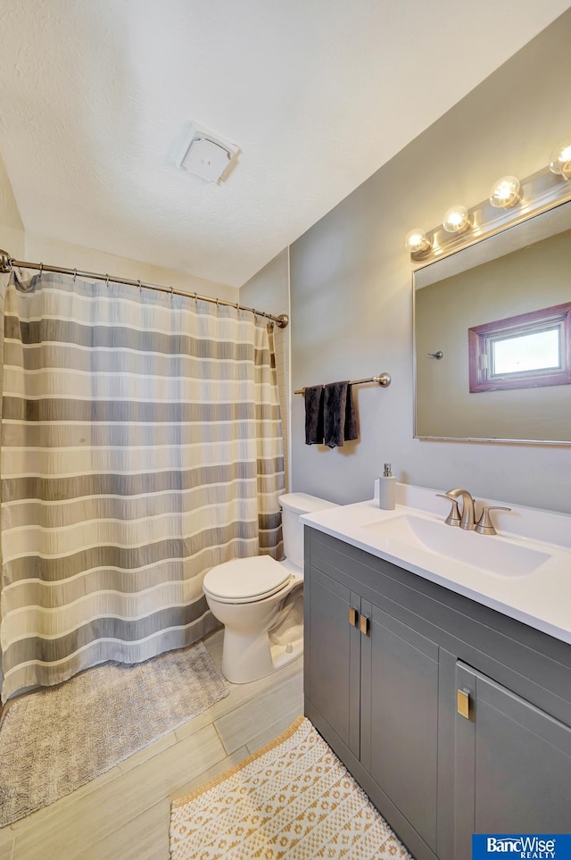 bathroom with toilet, curtained shower, and vanity