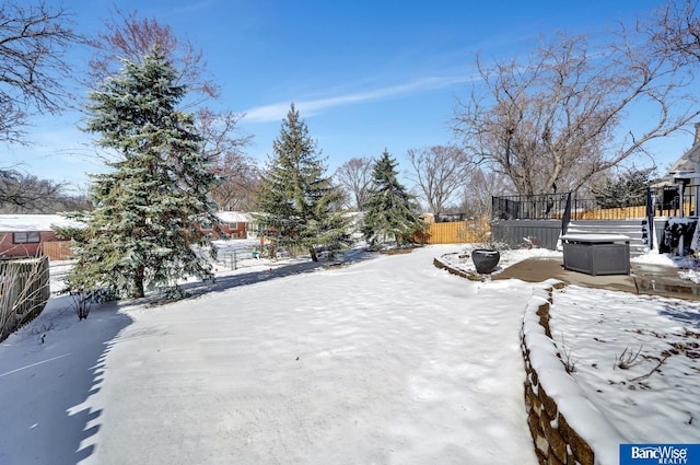 snowy yard featuring fence