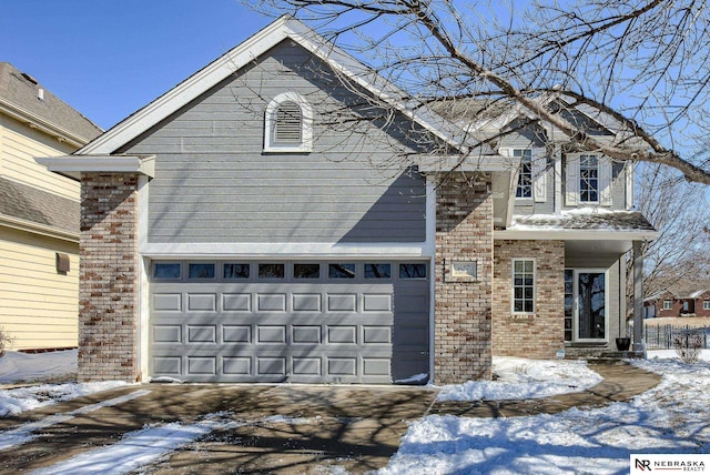 view of front of property with brick siding, driveway, and a garage