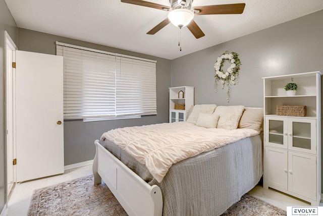 bedroom featuring ceiling fan, a textured ceiling, and light tile patterned floors