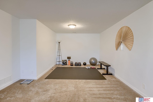 exercise area with baseboards, visible vents, and carpet flooring