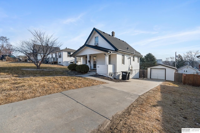 bungalow-style home featuring an outbuilding, driveway, a detached garage, a porch, and fence