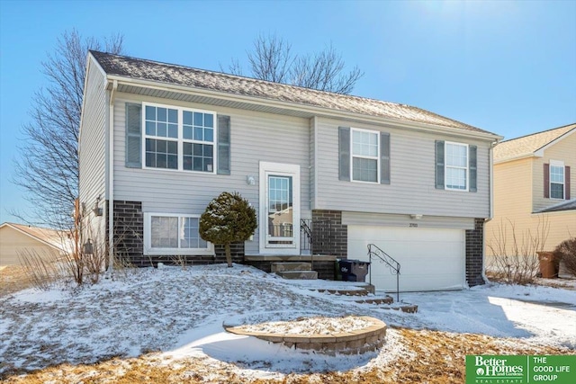 split foyer home with a garage and brick siding