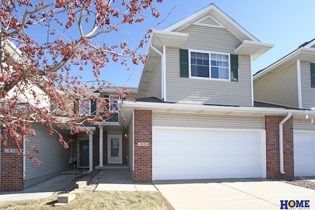 view of front of home featuring driveway, a garage, and brick siding