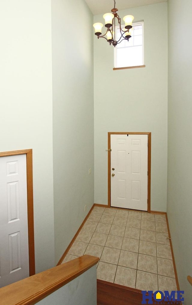 entrance foyer with light tile patterned floors, baseboards, and a chandelier