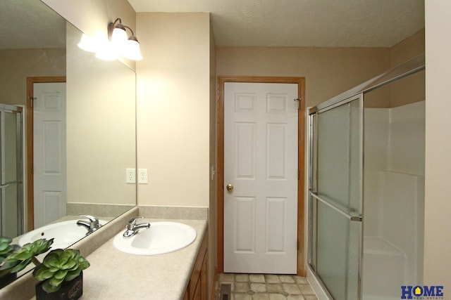 bathroom with a shower stall and vanity