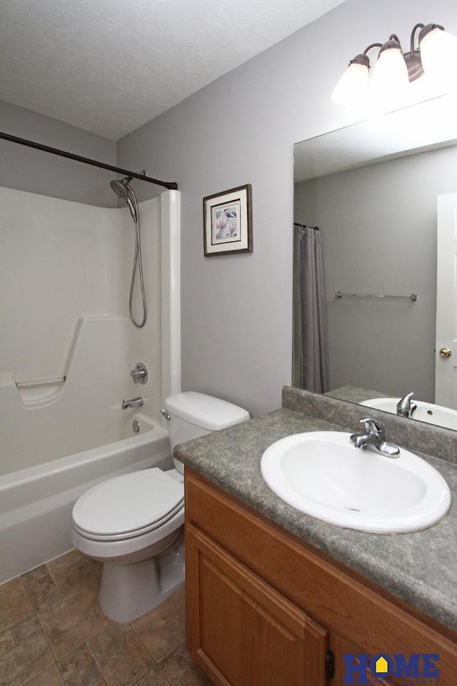 bathroom featuring toilet, a textured ceiling, shower / bath combo with shower curtain, and vanity