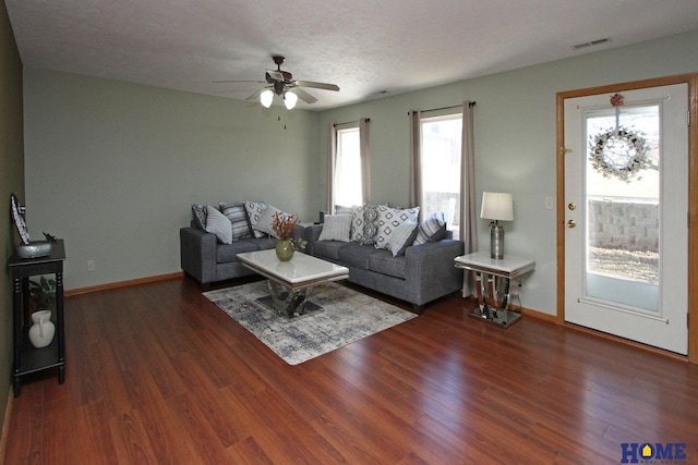 living room featuring ceiling fan, wood finished floors, visible vents, and baseboards