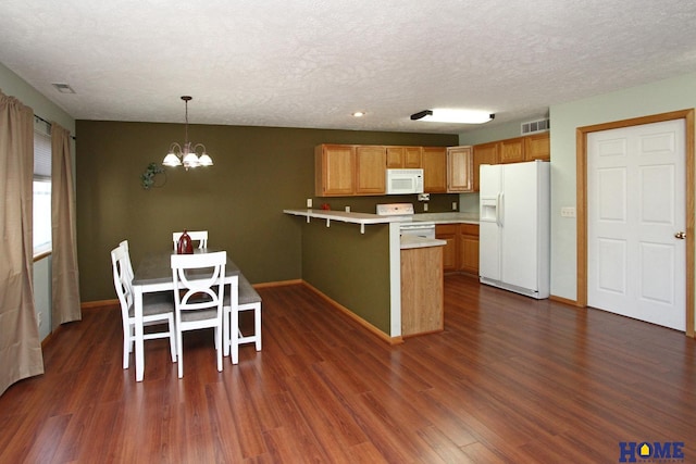 kitchen featuring white appliances, visible vents, dark wood-style floors, a peninsula, and light countertops