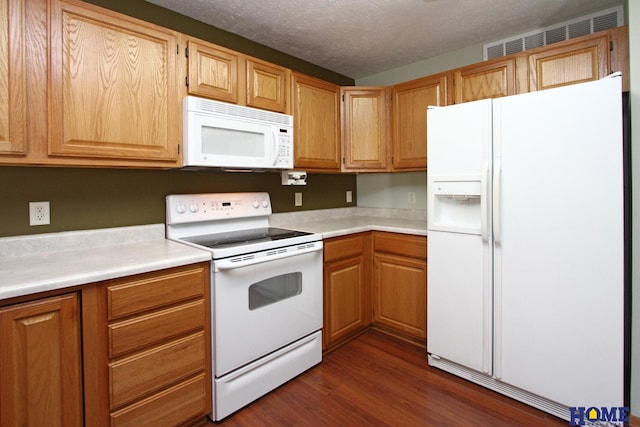 kitchen with white appliances, visible vents, dark wood-style floors, light countertops, and a textured ceiling