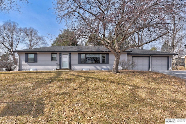 single story home featuring a garage, a front lawn, and aphalt driveway