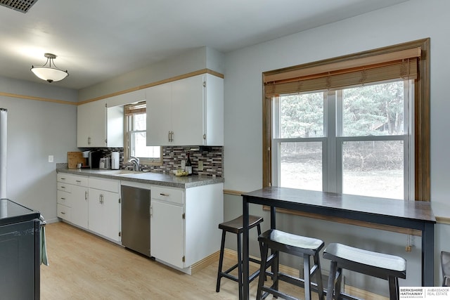 kitchen with white cabinets, light wood-style flooring, black / electric stove, stainless steel dishwasher, and backsplash