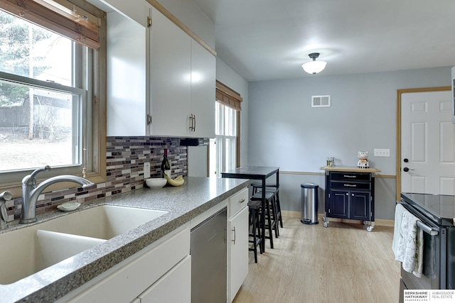 kitchen featuring a sink, visible vents, black electric range, stainless steel dishwasher, and decorative backsplash