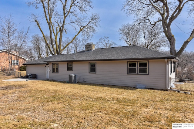 back of house featuring a yard, cooling unit, fence, and a chimney