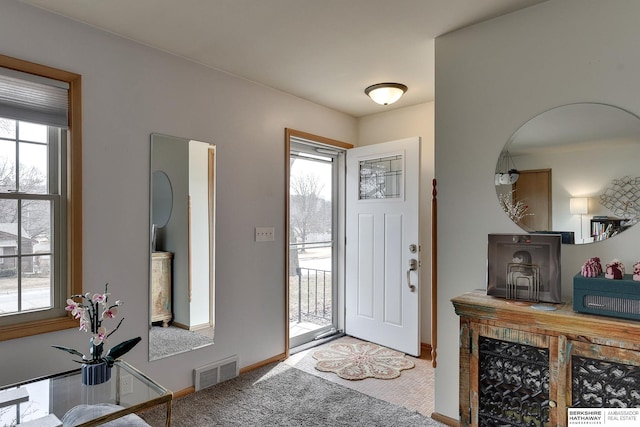 carpeted entrance foyer featuring visible vents and baseboards