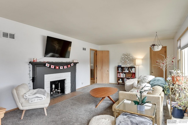 carpeted living room featuring a brick fireplace, visible vents, and baseboards