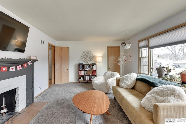 carpeted living area with a fireplace with flush hearth, visible vents, and baseboards