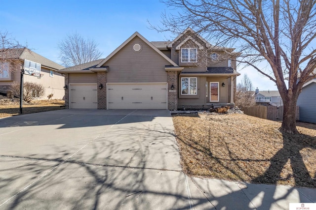 traditional-style home with brick siding, fence, driveway, and an attached garage