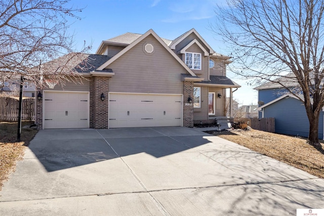 view of front of property featuring a garage, brick siding, and fence