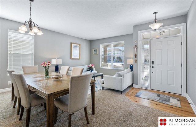 dining room with light wood-style floors, baseboards, and a chandelier