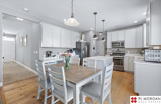 10211 Rosewater Pkwy, Bennington, NE 68007 - kitchen with light wood-style flooring, stainless steel appliances, light countertops, and a center island