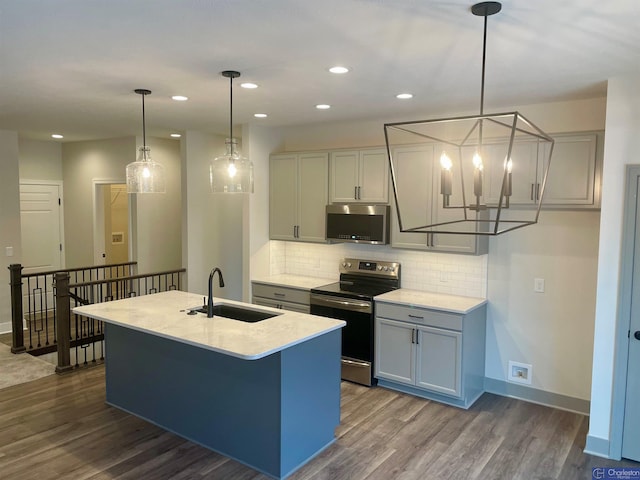 kitchen featuring dark wood finished floors, a sink, stainless steel appliances, light countertops, and backsplash