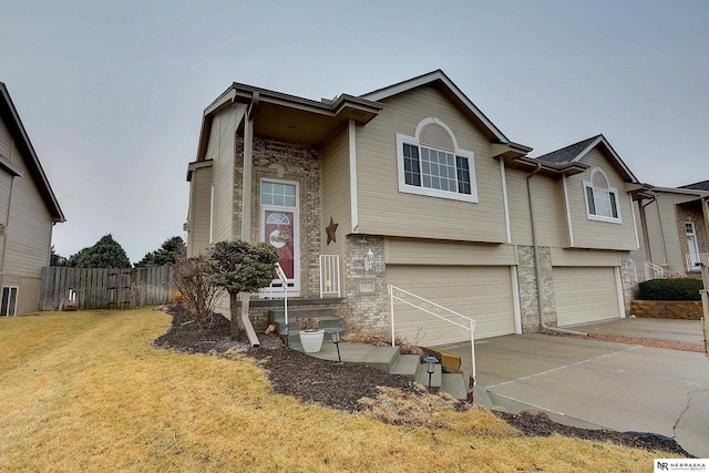 view of front facade featuring driveway, stone siding, an attached garage, fence, and a front lawn