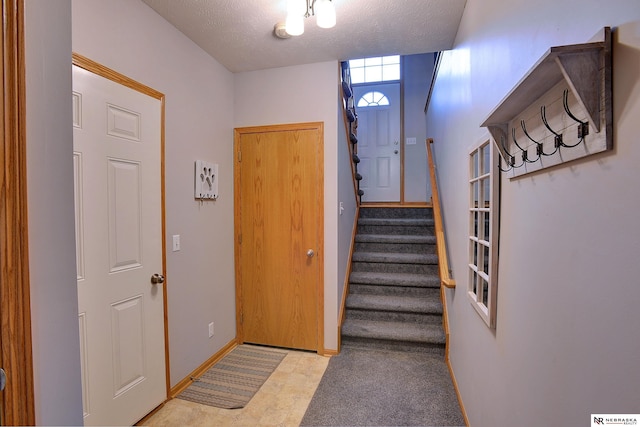 interior space featuring a textured ceiling, tile patterned floors, and baseboards