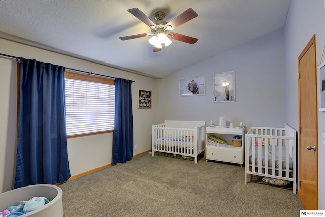 bedroom with carpet floors, baseboards, vaulted ceiling, and a crib