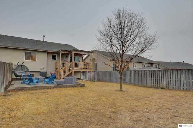 back of house featuring a patio area, a fenced backyard, stairs, and a lawn