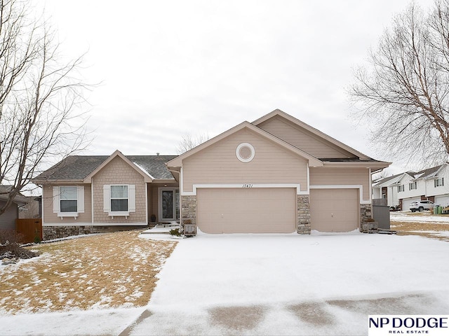 view of front facade featuring an attached garage, stone siding, driveway, and a shingled roof