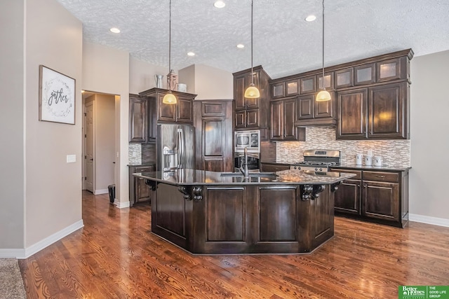 kitchen with dark wood finished floors, dark brown cabinets, appliances with stainless steel finishes, and a sink