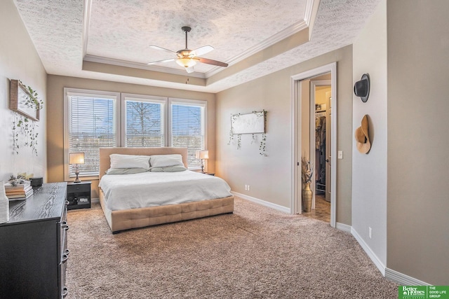 bedroom with crown molding, baseboards, carpet, a textured ceiling, and a raised ceiling