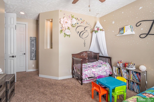 carpeted bedroom featuring baseboards, a textured ceiling, and ceiling fan