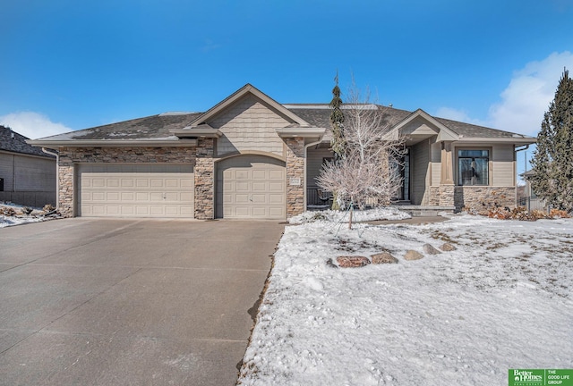 view of front facade with stone siding, driveway, a shingled roof, and a garage