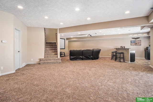 unfurnished living room featuring carpet flooring, a dry bar, stairs, and baseboards