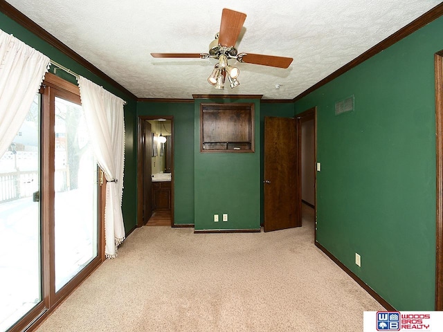 unfurnished room with a textured ceiling, ceiling fan, light carpet, baseboards, and ornamental molding