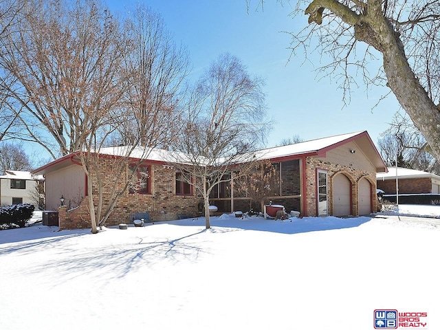 view of front of property with a sunroom and brick siding