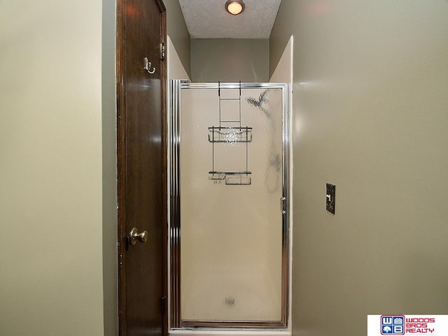 bathroom featuring a stall shower and a textured ceiling