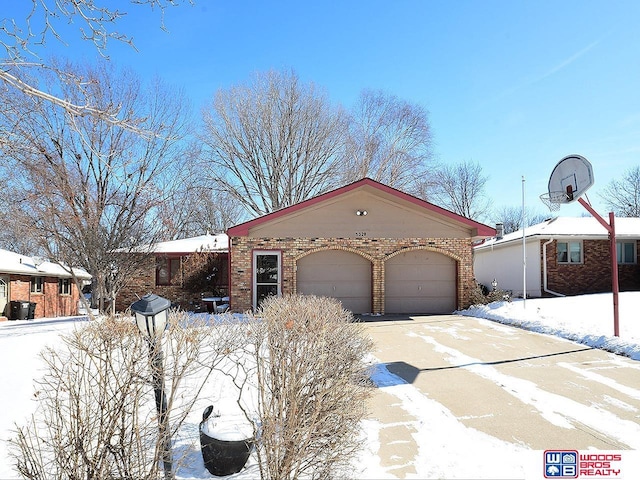 view of front of house featuring driveway, a garage, and brick siding