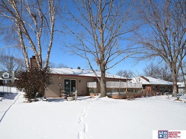 snow covered property featuring a chimney
