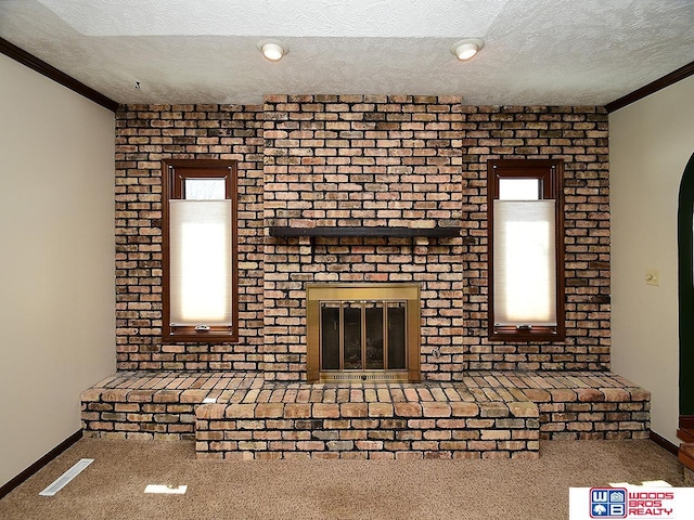 unfurnished living room with visible vents, crown molding, a textured ceiling, carpet floors, and a brick fireplace