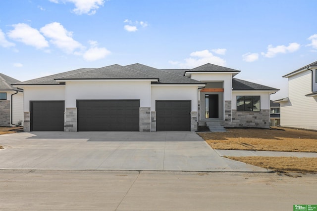 prairie-style home featuring an attached garage, stone siding, driveway, and stucco siding