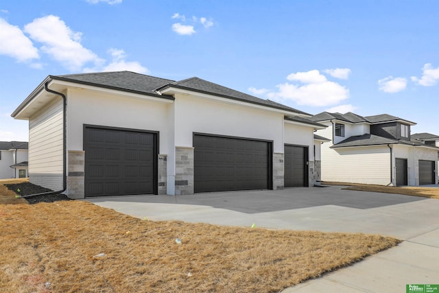 view of front of house featuring an attached garage, stone siding, driveway, and a shingled roof