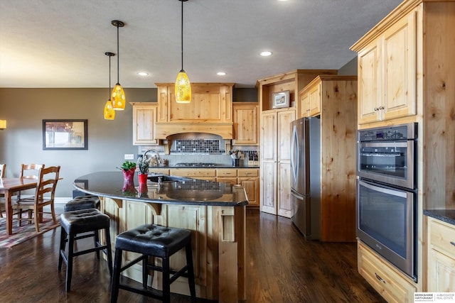 kitchen featuring a sink, appliances with stainless steel finishes, dark countertops, and light brown cabinets