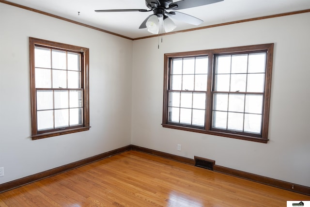 unfurnished room featuring ornamental molding, light wood finished floors, plenty of natural light, and baseboards