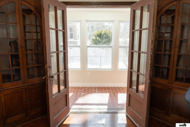 entryway featuring a wealth of natural light, french doors, and baseboards