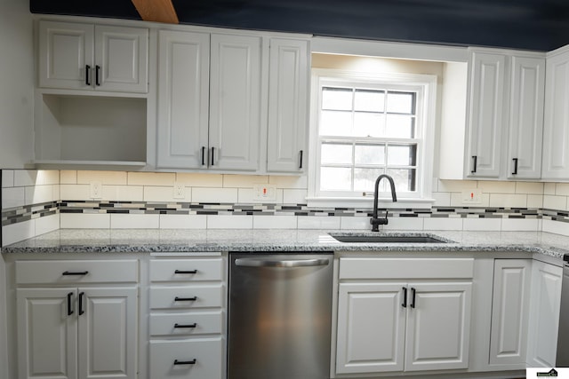 kitchen featuring white cabinetry, dishwasher, backsplash, and a sink